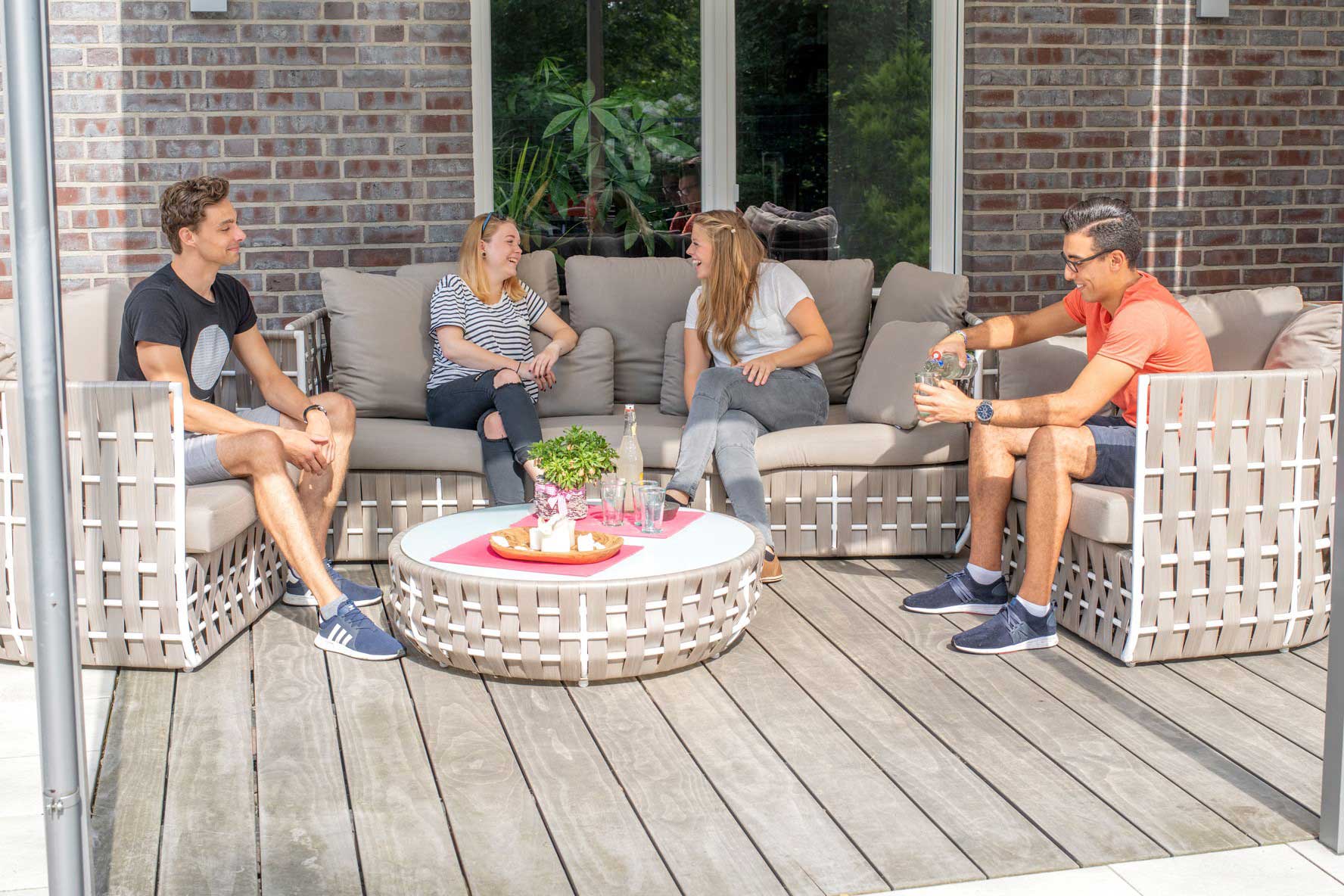 Familie sitzt auf einer Terrasse